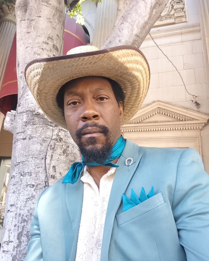 Powder blue jacket with a teal ascot and a four point pocket square