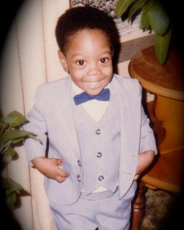 George Gentleman as a small child in a grey three piece suit and a blue bow tie